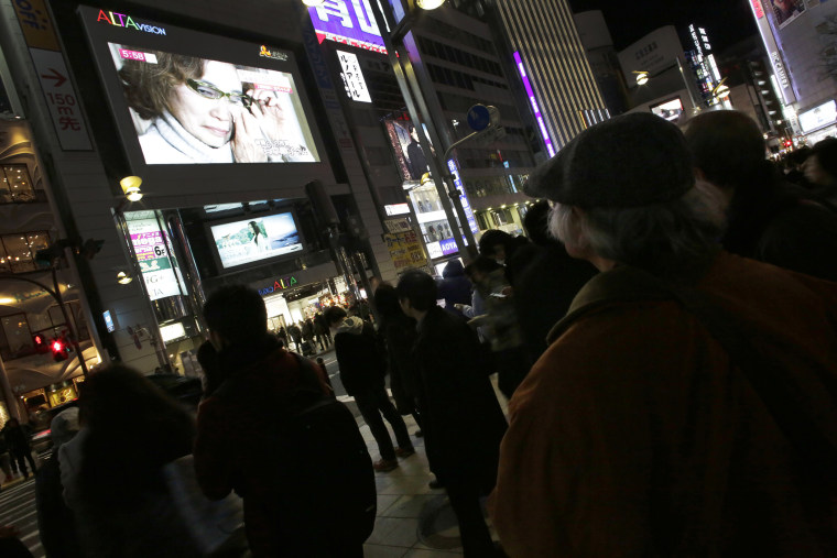 A giant TV monitor shows Junko Ishido, mother of Japanese journalist Kenji Goto who was taken hostage by the Islamic State group, in Tokyo, on Jan. 23, 2015.