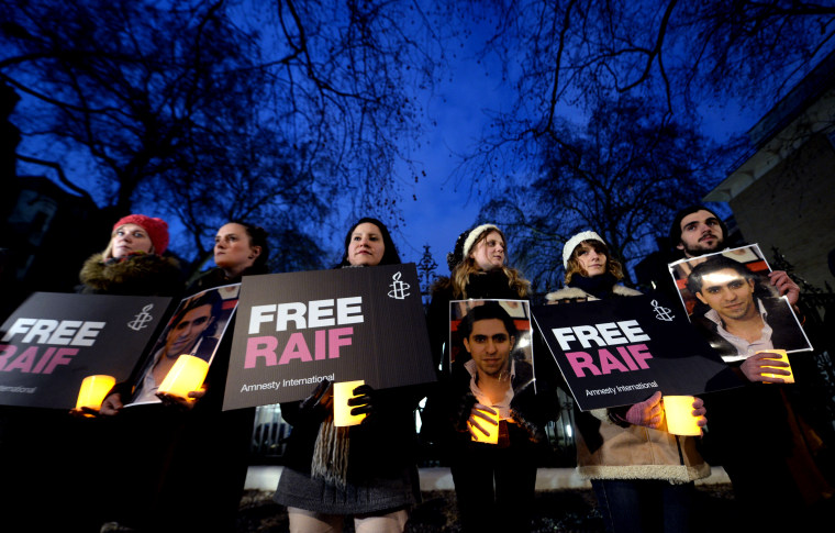 Protesters during a candle-lit protest vigil for blogger and free speech activist Raif Badawi outside the Saudi embassy in Mayfair, London, Jan. 22, 2015. (Photo by Anthony Devlin/PA Wire)