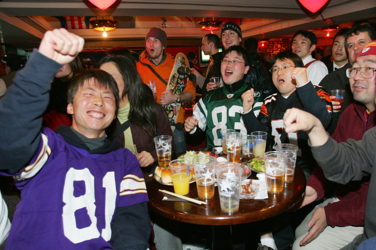 Japanese football fans cheer as they watch the NFL's Super Bowl XL game between Pittsburgh Steelers and Seattle Seahawks on television at a sports bar in Tokyo on Feb., 6, 2006.