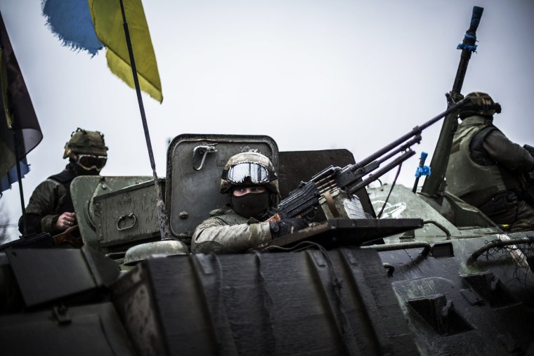 Ukrainian soldiers are seen in an armoured vehicle topped with a Ukrainian flag near the city of Artemivsk, in the Donetsk region, before heading to the city of Debaltseve on Feb., 1, 2015. (Photo by Manu Brabo/AFP/Getty)
