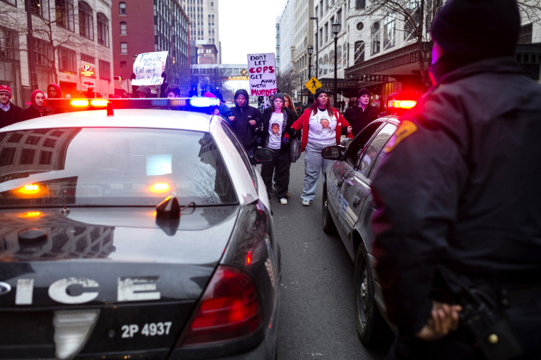 Demonstrators lock arms and block two police cruisers on Ontario Street Dec. 21, 2014, in Cleveland, Ohio. Demonstrators from Ferguson travelled to Cleveland to unite with activists protesting the death of Tamir Rice. (Photo by Angelo Merendino/Getty)