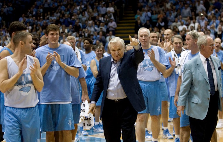 Surrounded by decades of former University of North Carolina players, coach Dean Smith receives a standing ovation after being honored during the Celebration of a Century in Chapel Hill, NC, Feb. 12, 2010. (Photo by Robert Willett/MCT via Getty)