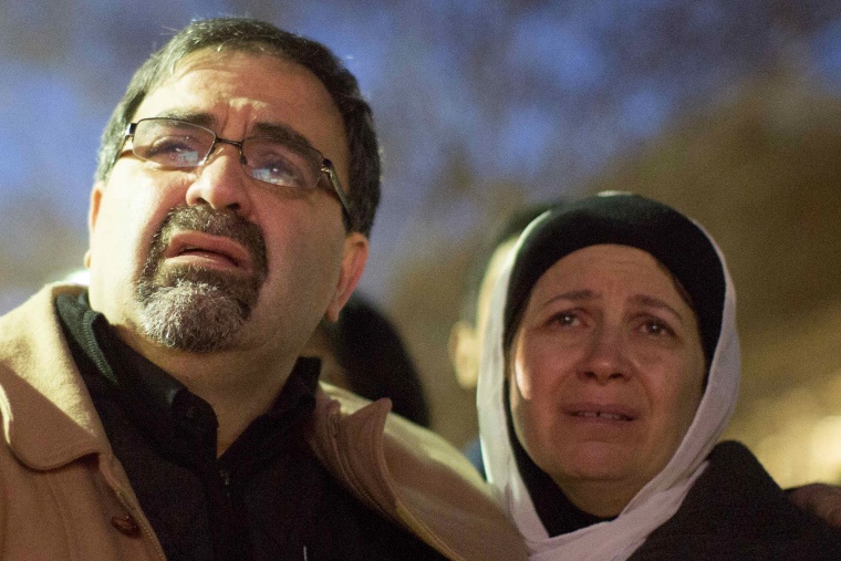 Namee Barakat and his wife Layla Barakat, parents of shooting victim Deah Shaddy Barakat, react as a video is played during a vigil on the campus of the University of North Carolina in Chapel Hill, N.C. on Feb. 11, 2015.