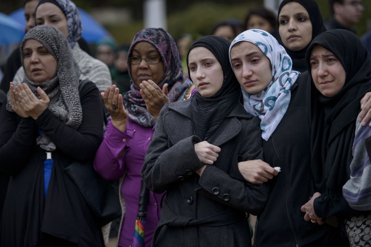 People listen to a funeral prayer during a burial on Feb. 12, 2015 in Wendell, N.C.