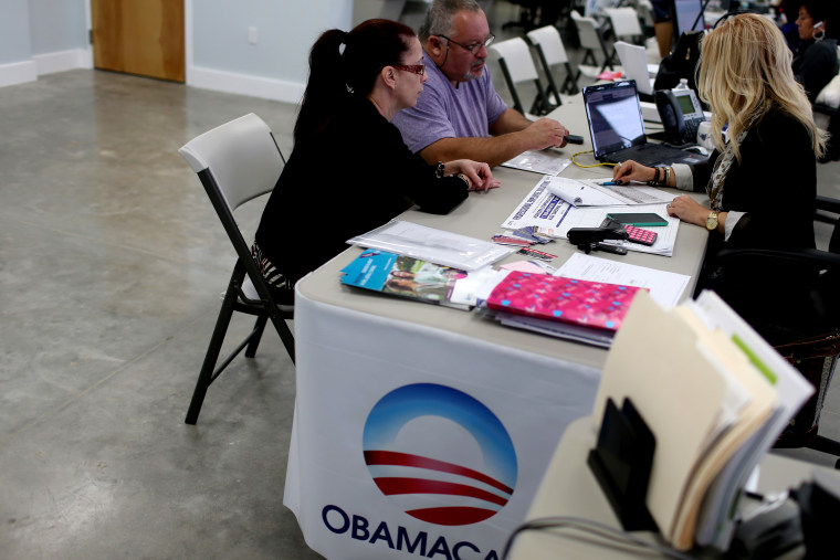 Aymara Marchante and Wiktor Garcia sit with UniVista insurance advisor Maria Elena Santa Coloma as they sign up for the Affordable Care Act, also known as Obamacare, on Feb. 5, 2015 in Miami, Florida. (Photo by Joe Raedle/Getty)