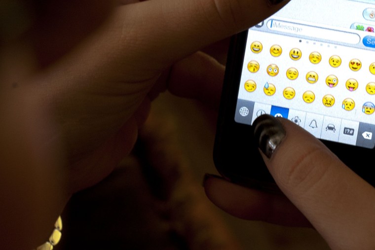 An iPhone owner uses emoji icons while texting.