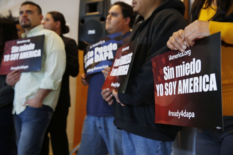 Supporters hold placards in support of immigration law changes during a news conference in the Denver Public Library, on Feb. 17, 2015, in Denver.