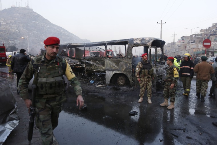 Afghan soldiers stand around a damaged bus at the site of a suicide attack by the Taliban in Kabul, Afghanistan on Dec. 13, 2014.