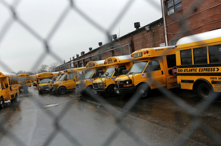 School buses are seen parked behind a locked bus depot fence in the Queens borough of New York Jan. 16, 2013. (Photo by Shannon Stapleton/Reuters)