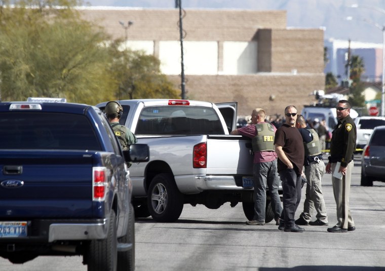 Las Vegas Metro Police officers and FBI agents stand in the street after a stand-off in Las Vegas on Feb. 19, 2015.