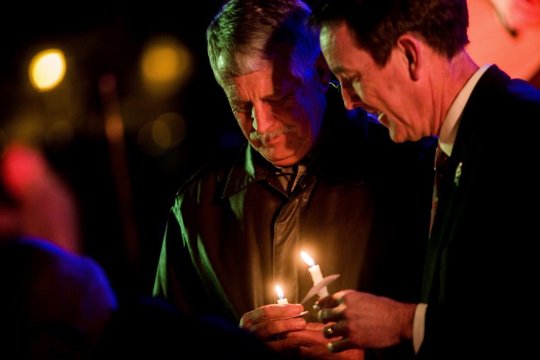 Carl Mueller holds his candle during a candlelight memorial honoring his daughter aid worker Kayla Mueller at the Prescott's Courthouse Square in Prescott, Ariz., Feb. 18, 2015. (Photo by Deanna Dent/Reuters)
