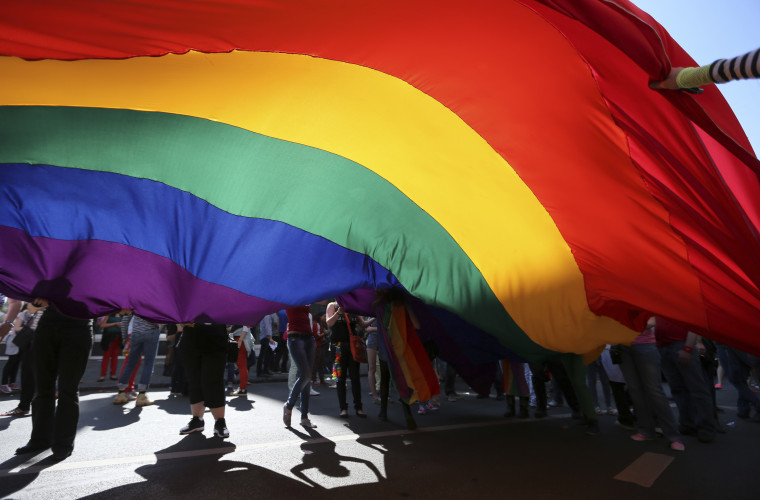 Participants hold a giant rainbow flag during the Brussels LGBT Pride Parade on May 17, 2014.