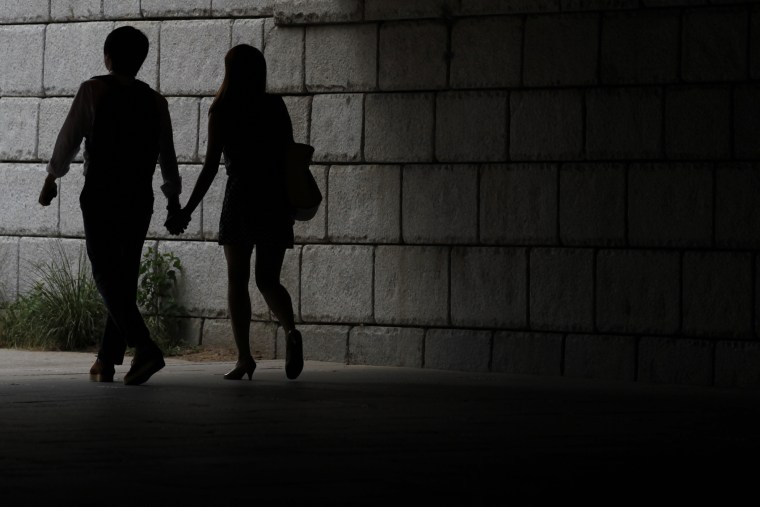 A young couple walks while holding hands under a bridge in central Seoul, South Korea. (Photo by Lee Jae Won/Reuters)