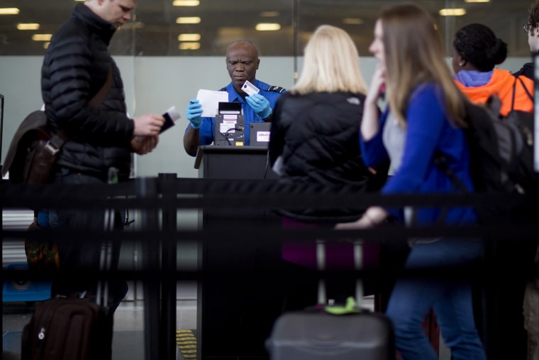 A Transportation Security Administration (TSA) officer checks a passenger's identification and boarding pass at a security checkpoint at Ronald Reagan National Airport in Washington, D.C., U.S., on Feb. 25, 2015. (Photo by Andrew Harrer/Bloomberg/Getty)
