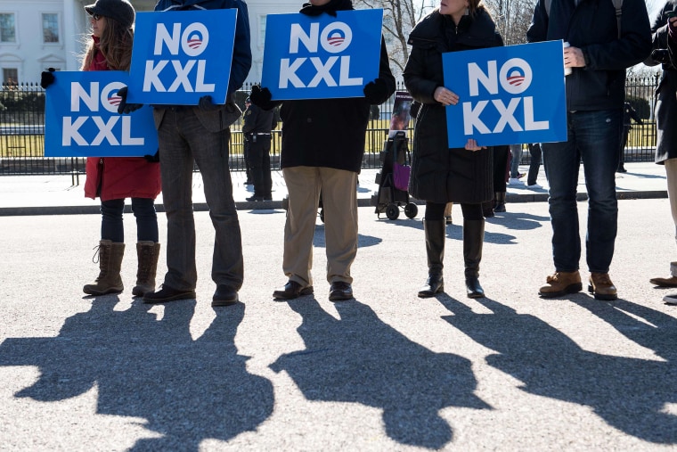 Demonstrators hold signs against the proposed Keystone XL pipeline from Canada to the Gulf of Mexico in front of the White House in Washington, DC. on Feb, 24, 2015.
