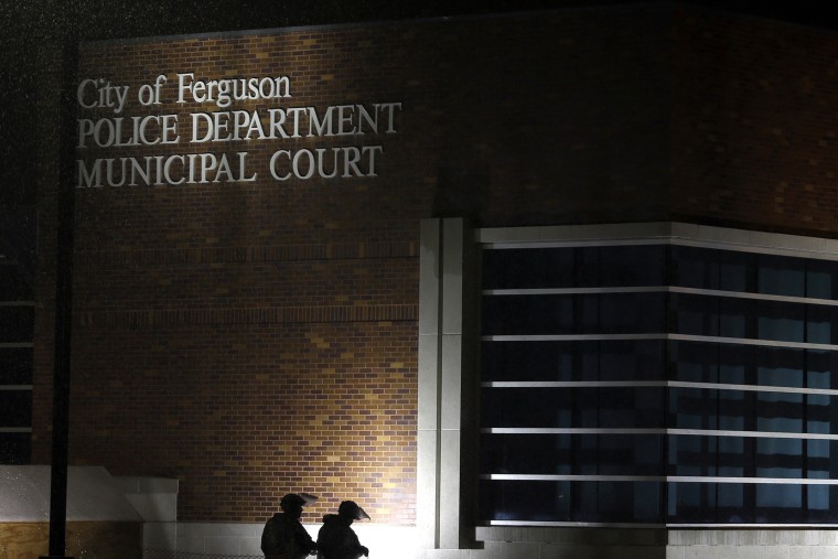 Members of Missouri National Guard stand outside of the Ferguson Police Department and the Municipal Court in Ferguson, Mo. on Nov. 26, 2014. (Photo by Jeff Roberson/AP)