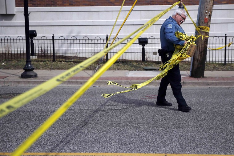 A police officer walks under the tape marking the perimeter around the Ferguson Police Department in Ferguson, Missouri on March 12, 2015.
