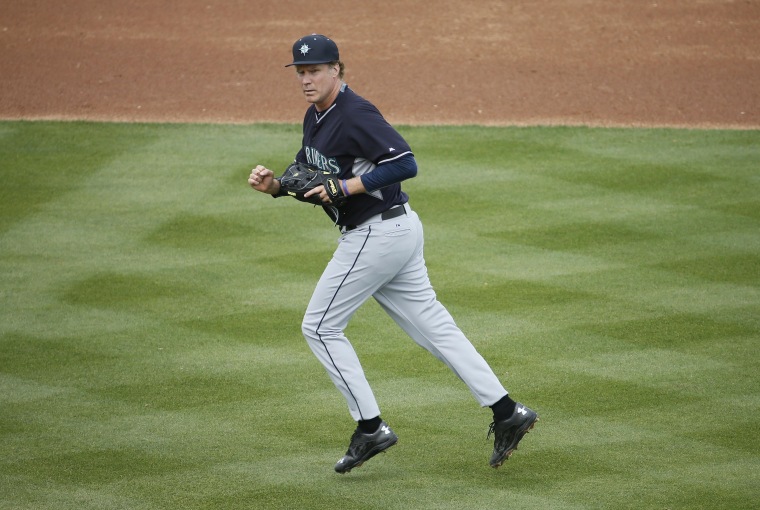 Actor Will Ferrell runs to the dugout after playing second base for the Seattle Mariners during the second inning of a spring training baseball game against the Oakland Athletics, on March 12, 2015, in Mesa, Ariz.