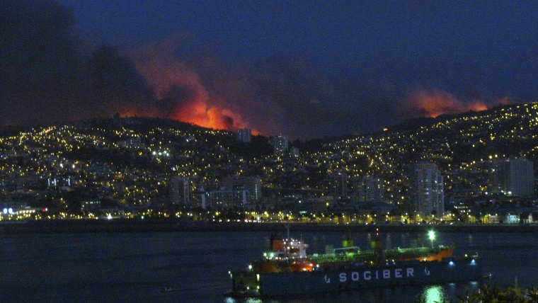 Smoke from a forest fire is seen in Valparaiso city, northwest of Santiago, Chile, March 13, 2015. A forest fire was raging out of control on Friday evening into Saturday, threatening the Chilean port city of Valparaiso. (Photo by Lucas Alvarado/Reuters)