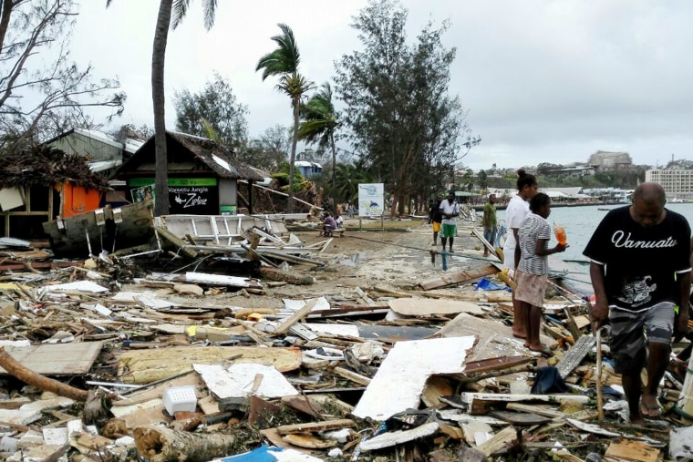 In this photo provided by China's Xinhua News Agency, locals walk past debris in Port Vila, Vanuatu, after Cyclone Pam ripped through the tiny South Pacific archipelago, March 15, 2015. (Photo by Luo Xiangfeng/Xinhua via AP)