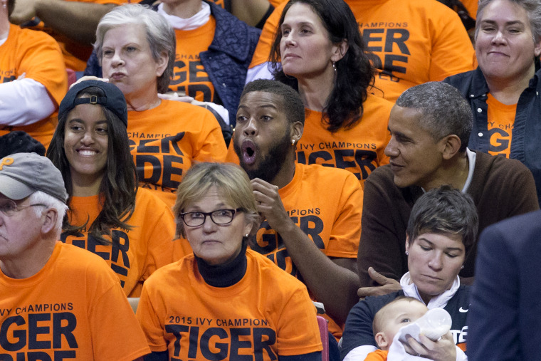 President Barack Obama sits with his nephew Avery Robinson and daughter Malia while attending the Green Bay versus Princeton women's college basketball game in the first round of the NCAA tournament, March 21, 2015. (Photo by MIchael Reynolds-Pool/Getty)