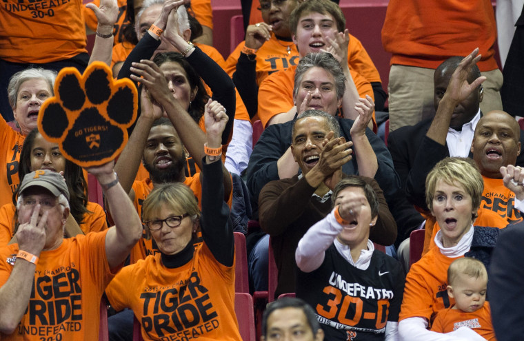 President Barack Obama, alongside his brother-in-law Craig Robinson, attends a NCAA Division I Women's College Basketball tournament game between Princeton and Green Bay in College Park, Maryland, March 21, 2015. (Photo by Saul Loeb/AFP/Getty)