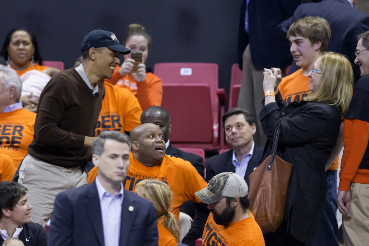 President Barack Obama poses for a photo while attending the Green Bay vs. Princeton women's college basketball game in the first round of the NCAA tournament, March 21, 2015. (Photo by MIchael Reynolds-Pool/Getty)