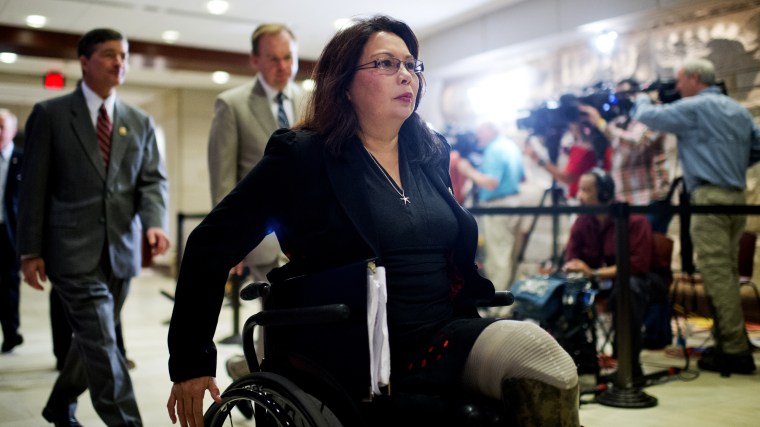 Rep. Tammy Duckworth, D-Ill., makes her way to a closed briefing in the Capitol Visitor Center for House members on the administration's strategy for combating ISIL, Sept. 11, 2014. (Photo By Tom Williams/CQ Roll Call via AP)