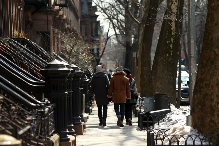 People walk down a street in the Fort Greene neighborhood of Brooklyn on Feb. 27, 2014.