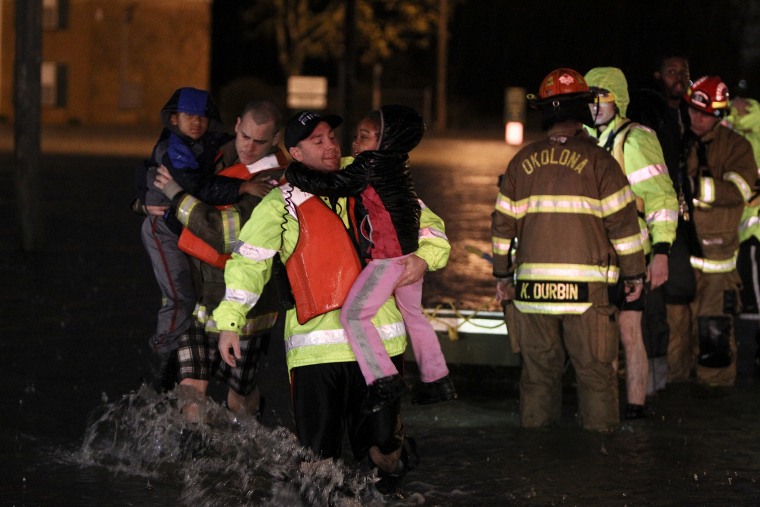 Rescue crews help residents at the Guardian Court Apartments evacuate after flooding in the area on April 3, 2015 in Louisville, Ky. (Photo by Michael Clevenger/The Courier-Journal via AP)