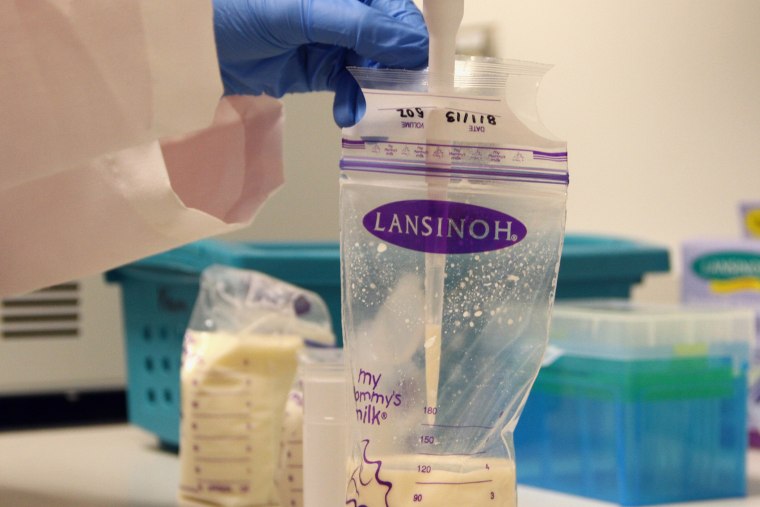 A researcher takes a sample of breast milk.