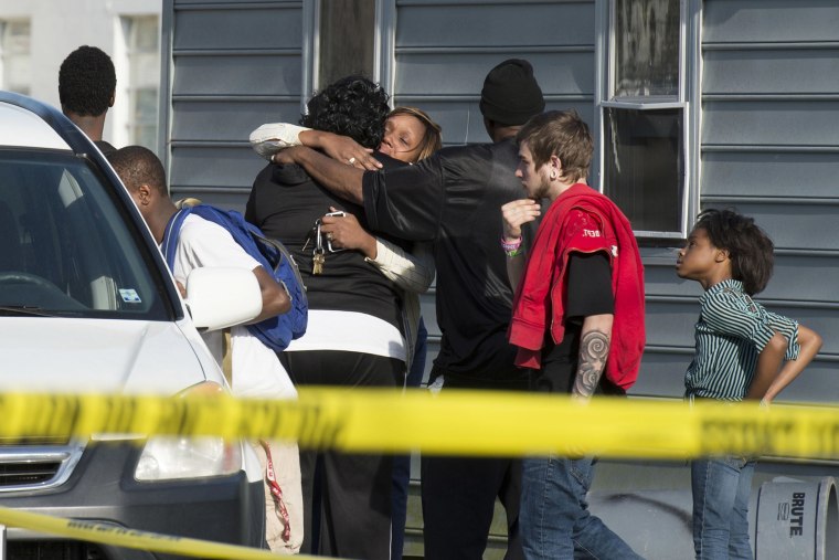 Onlookers gather outside of a house, where police say seven children and one adult were found dead on April 6, 2015, in Princess Anne, Md. (Photo by Joe Lamberti/The Daily Times/AP)