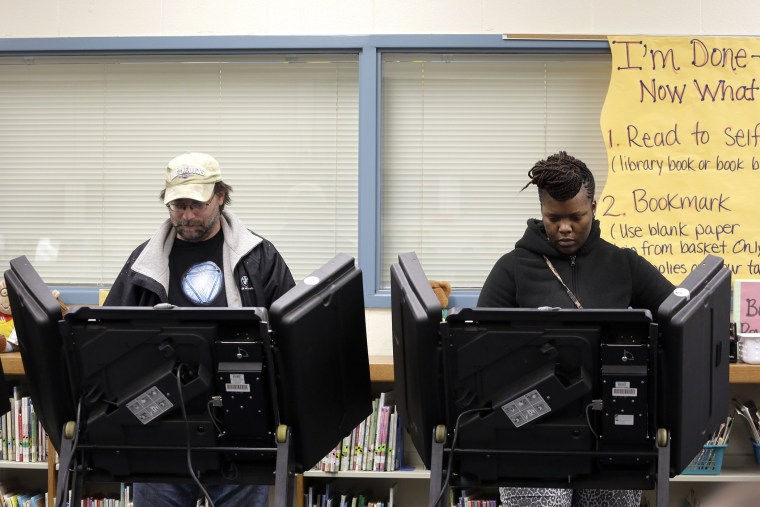 Rich Baranowski, left, and Tracy Hardy vote in Ferguson's municipal election, April 7, 2015, in Ferguson, Mo. (Photo by Jeff Roberson/AP)