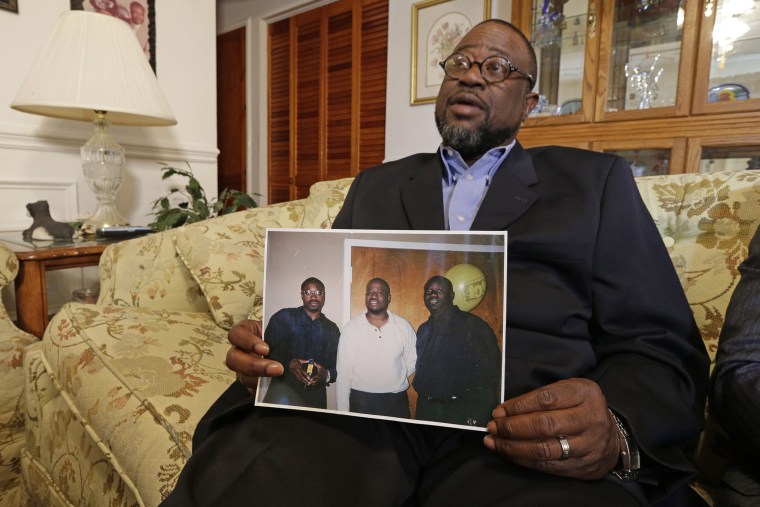 Anthony Scott holds a photo of himself, center, and his brothers Walter Scott, left, and Rodney Scott, right, as he talks about his brother at his home near North Charleston, S.C., on April 8, 2015.