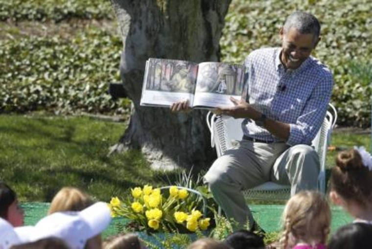 U.S. President Barack Obama laughs as he reads the storybook \"Where the Wild Things Are\" during the annual Easter Egg Roll at the White House in Washington