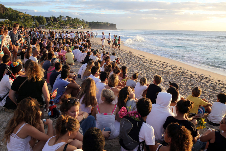 Several hundreds of people gather on the beach in Les Aigrettes, on the western coast of the French Indian Ocean island of La Reunion, on April 12, 2015 to pay tribute to a 13-year-old boy who was attacked and killed by a shark.