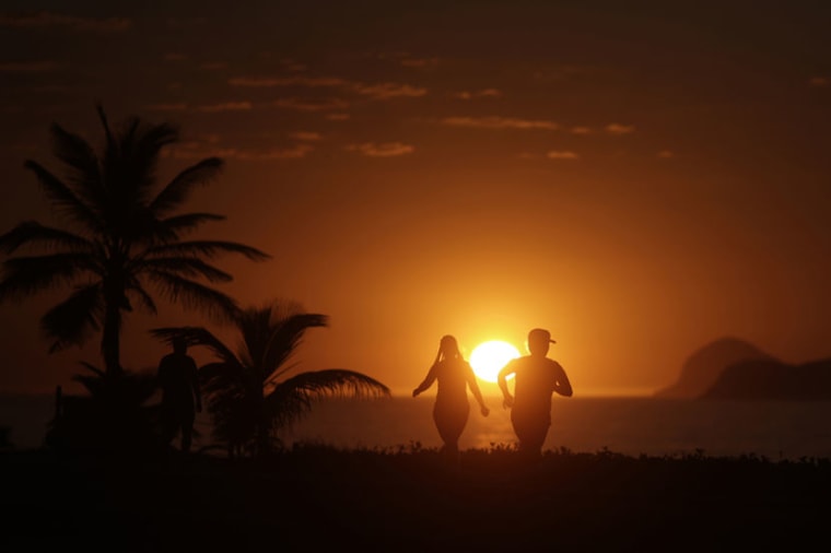 People exercise in Barra da Tijuca beach during the sunrise in Rio de Janeiro January 31, 2014. (Photo by Ricardo Moraes/Reuters)