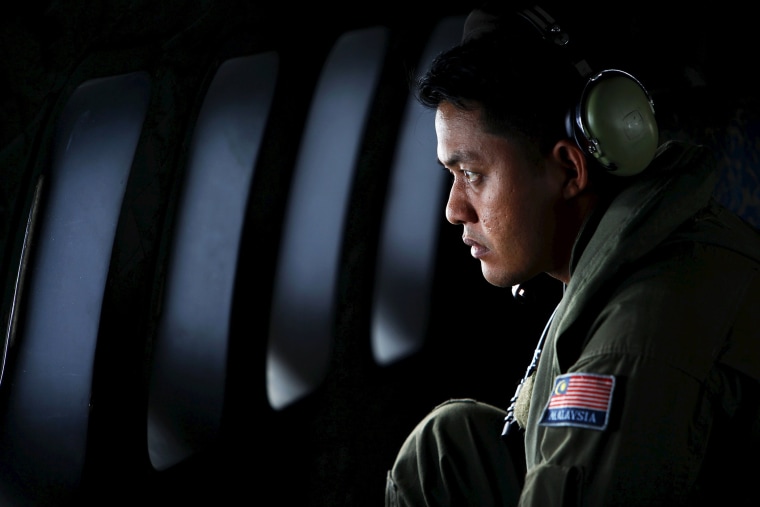A crew member from the Royal Malaysian Air Force looks through the window of a Malaysian Air Force CN235 aircraft during a Search and Rescue (SAR) operation to find the missing Malaysia Airlines flight MH370 March 13, 2014.