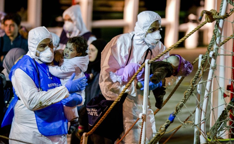 Rescuers help children to disembark in the Sicilian harbor of Pozzallo, Italy on April 20, 2015.