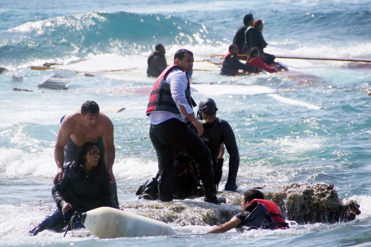 A man rescues a migrant from the Aegean sea, in the eastern island of Rhodes, on April 20, 2015.