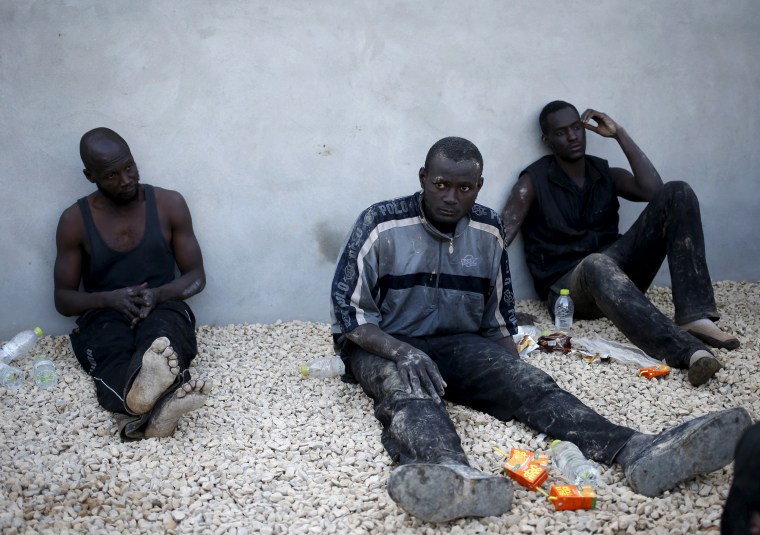 Illegal migrants sit in a coastal police base in Tripoli on March 13, 2015. Police captured 96 illegal migrants in a boat as they tried to cross the Mediterranean to Italy.