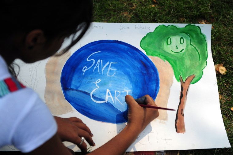 An Indian child paints during an awareness event organized by the Aakalpan Artist Society commemorating Earth Day in Allahabad on April 22, 2013.
