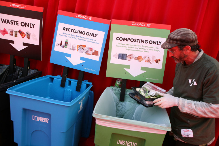 A worker separates recyclables and compost materials at the Oracle Open World conference September 22, 2008 at the Moscone Center in San Franciscso, Calif.