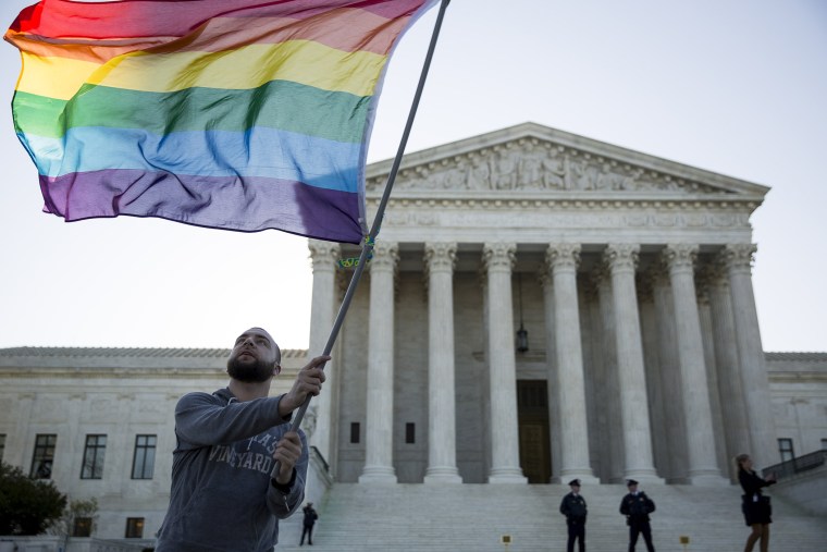 Same-sex marriage supporter Vin Testa, of Washington, DC, waves a rainbow pride flag near the Supreme Court, April 28, 2015 in Washington, DC.