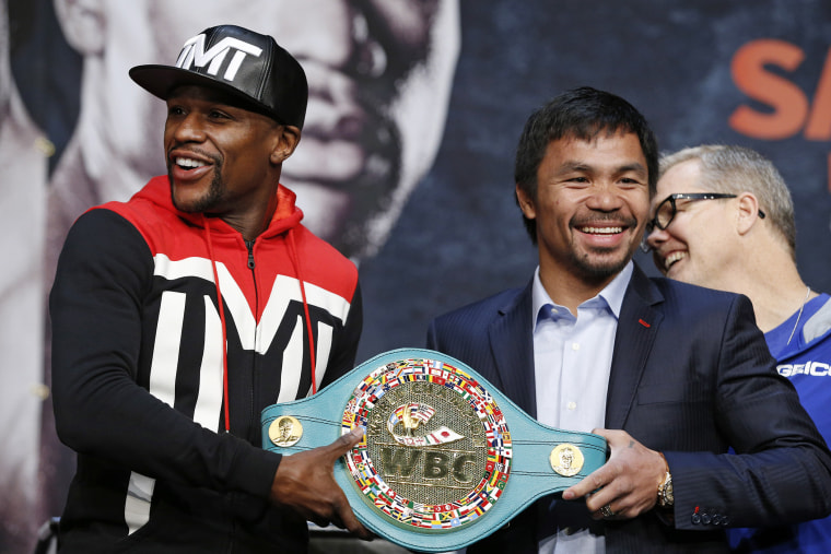 Boxers Floyd Mayweather Jr., left, and Manny Pacquiao pose with a WBC belt during a press conference, April 29, 2015, in Las Vegas. (Photo by John Locher/AP)