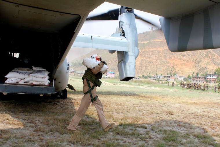 A U.S. Marine unloads rice from a Boeing V-22 Osprey in the Nepali village of Panchkal.