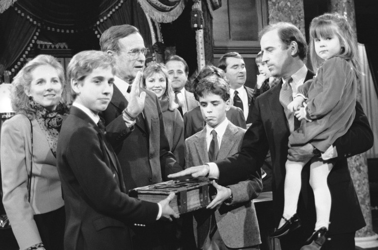 Sen. Joe Biden holds his daughter Ashley while taking a mock oath of office from Vice President George Bush during a ceremony on Capitol Hill, Jan. 3, 1985. Biden's sons Beau and Hunter hold the bible during the ceremony. (Photo by Lana Harris/AP)
