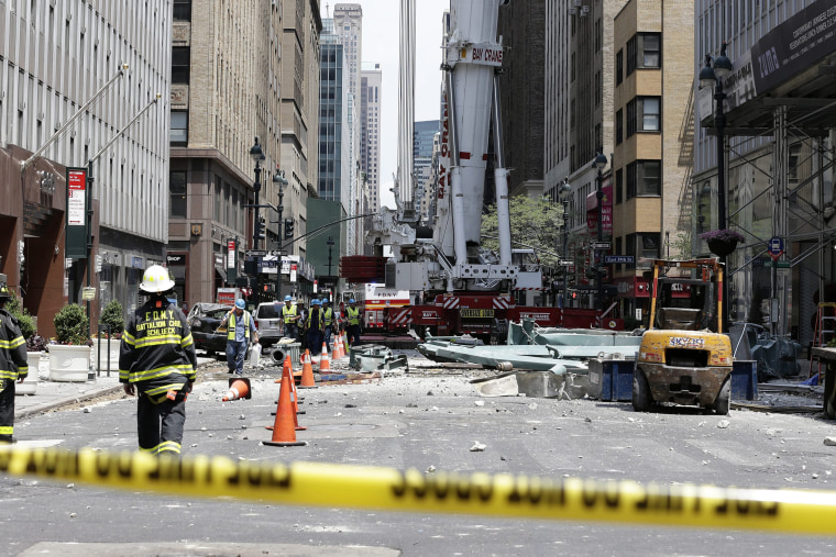 New York City officials and fire officials walk in front of a crane collapse on Madison Avenue between 38th and 39th street in New York, N.Y., on May 31, 2015. (Photo by Jason Szenes/EPA)