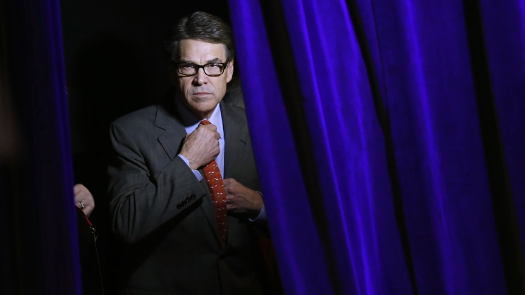 Former Governor of Texas Rick Perry adjusts his tie as he listens to his introduction from the side of the stage at the Freedom Summit in Des Moines, Iowa, Jan. 24, 2015. (Photo by Jim Young/Reuters)