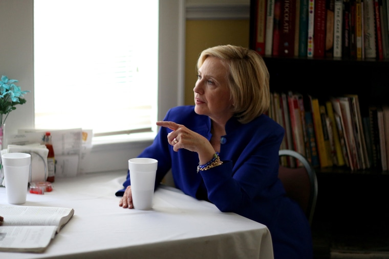 Democratic Presidential candidate Hillary Clinton sits with a customer as she visits the Main Street Bakery on May 27, 2015 in Columbia, S.C. (Photo by Joe Raedle/Getty)